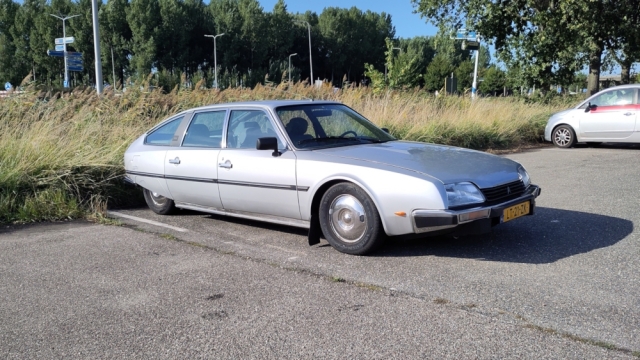 Grijze Citroën CX staat op de carpoolplaats, plat op de grond.